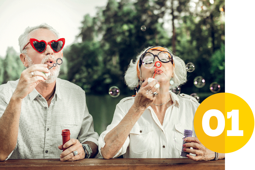 older couple with silly glasses blowing bubbles outdoor, Susan Charles headshot