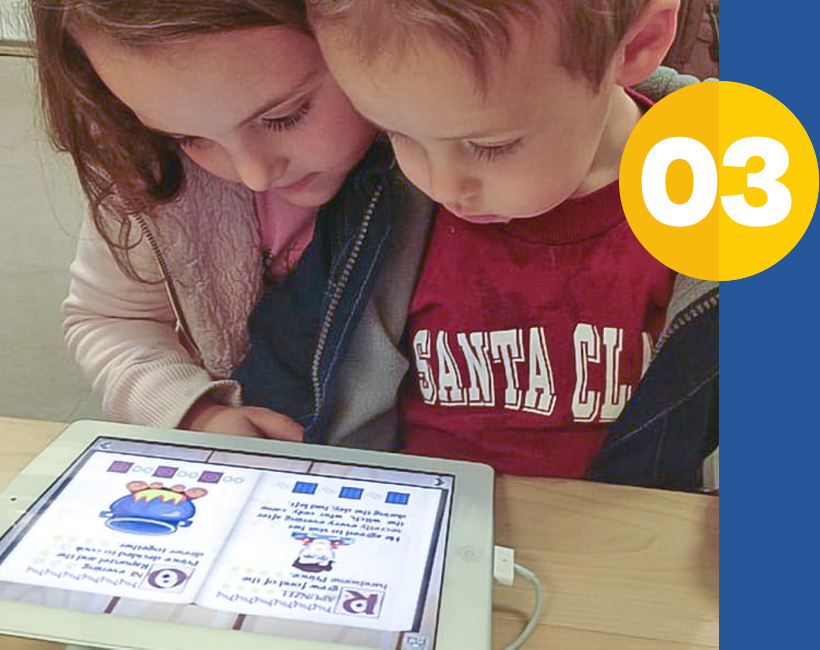 two young children looking at ipad