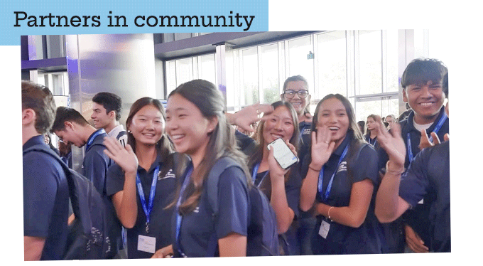 Partners in Community: high school students smiling and waving at the Irvine Spectrum Center