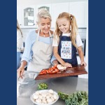 Older adult preparing meal with child in the kitchen.