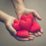 A pair of hands holding out heart-shaped objects.