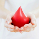 Hands hold out an object that looks like a blood droplet.